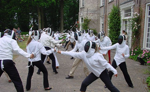 Foto van een bedrijfsuitje waarop meerdere personen aan het schermen zijn